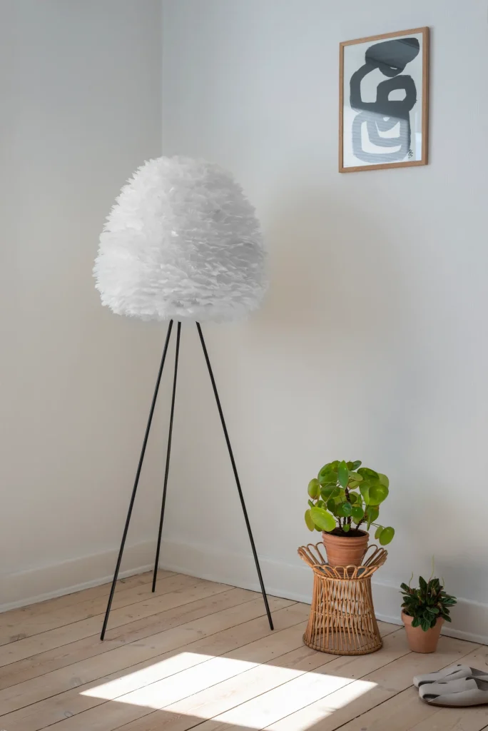 Lampadaire trepied Umage Eos dans une pièce avec du parquet massif