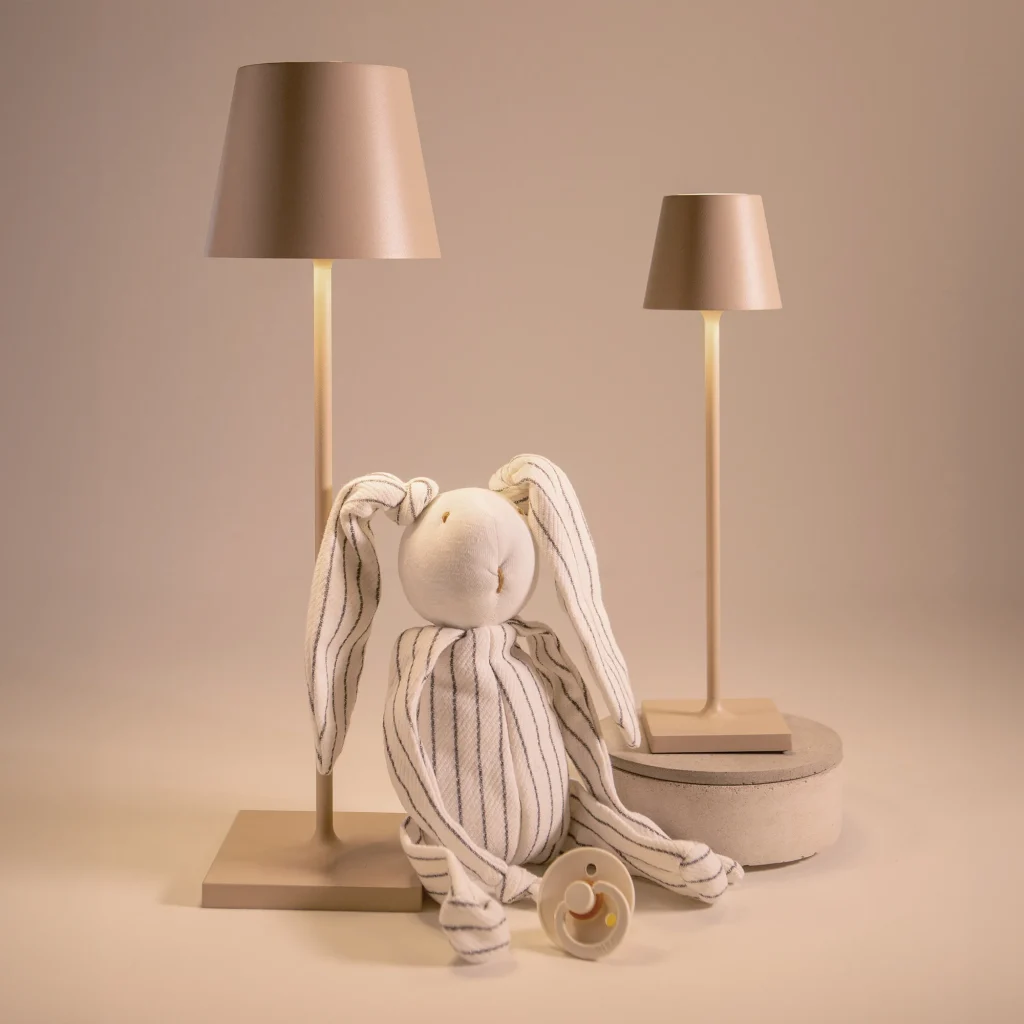 Lampes sans fil Zafferano Poldina Pro en aluminium à côté d'une peluche lapin